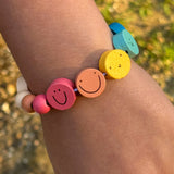 Completed smiley face bracelet on child's wrist