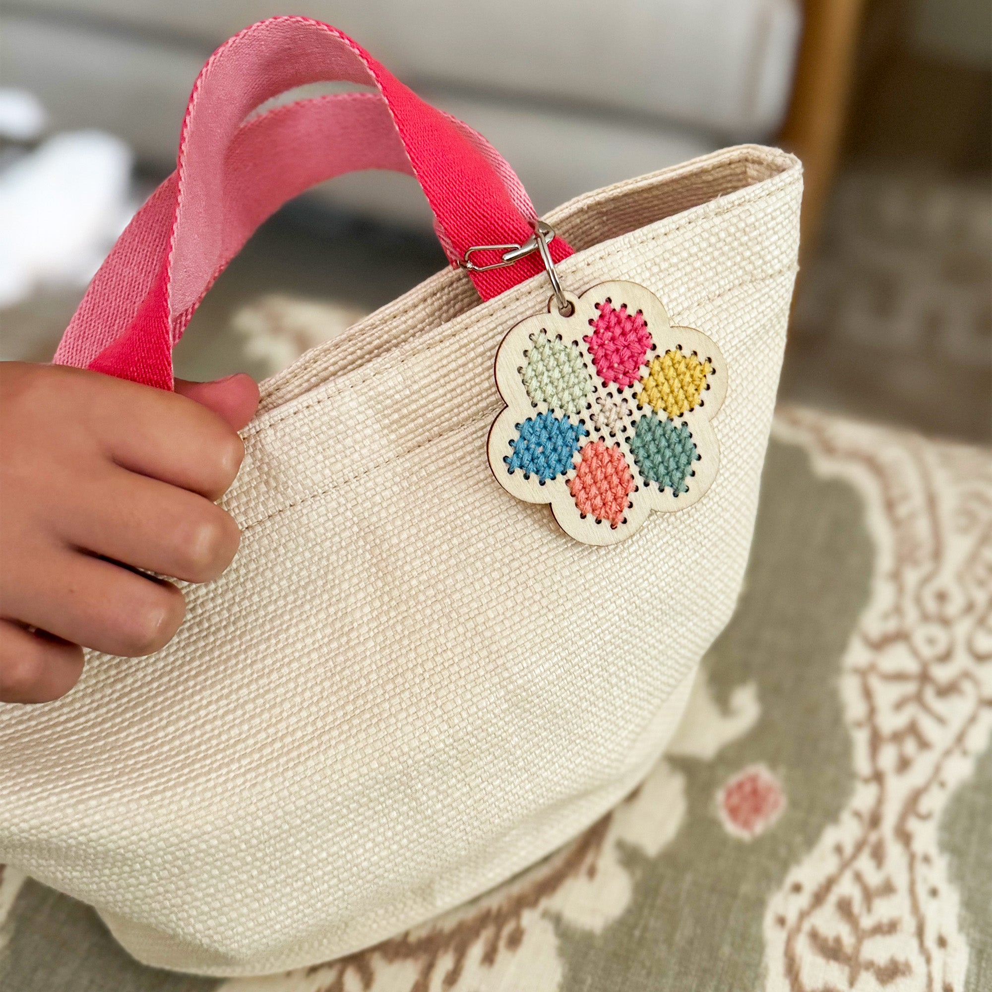 Finished wooden flower keyring featuring stitched patterns in pastel threads.