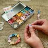 "It's Nice To Be Nice" bracelet beading kit displayed with colourful wooden beads and smiley face charms.