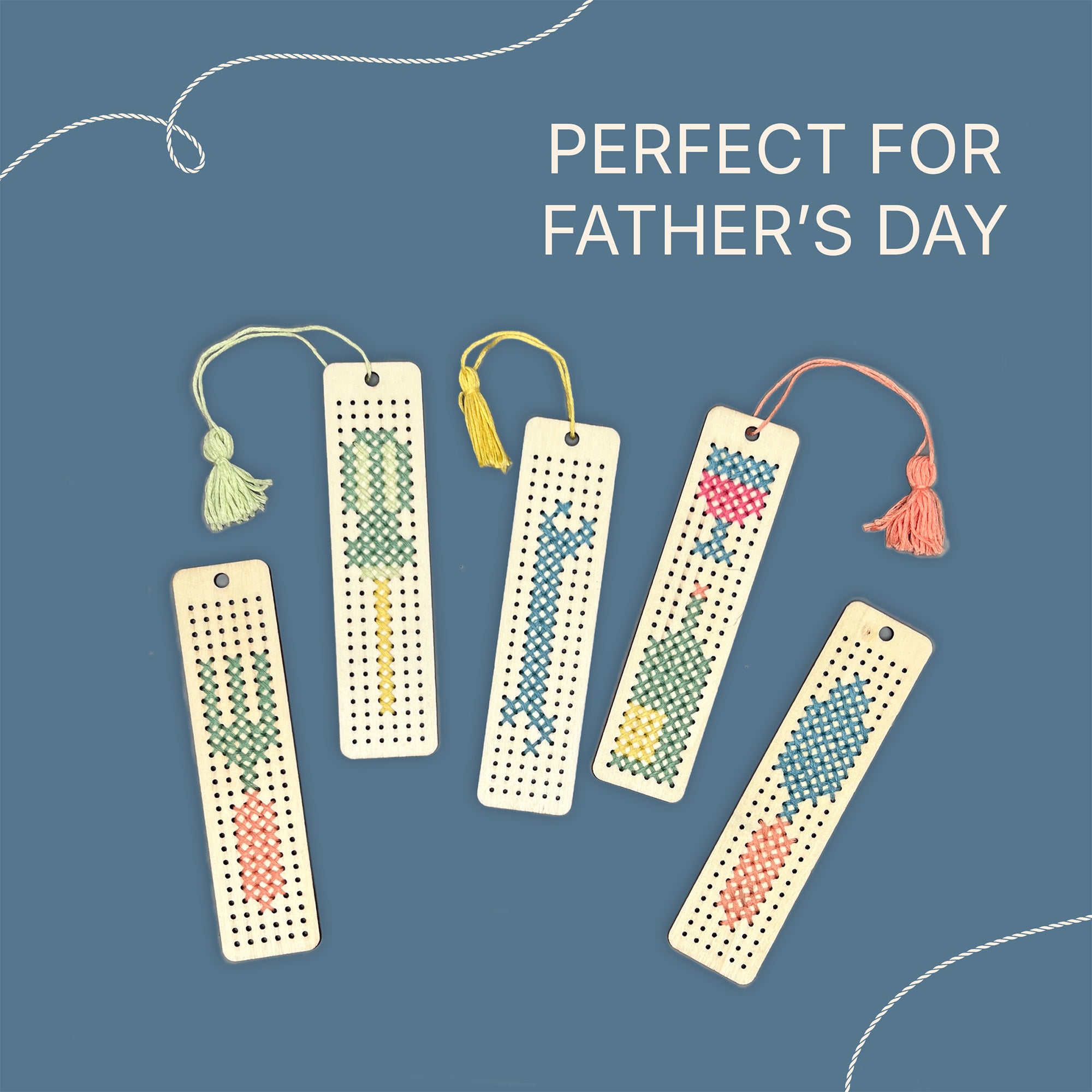 5 finished wooden bookmarks with stitched patterns depicting a selection of 4 different tools and a wine bottle with colourful tassels attached. Text says "perfect for Father's Day"