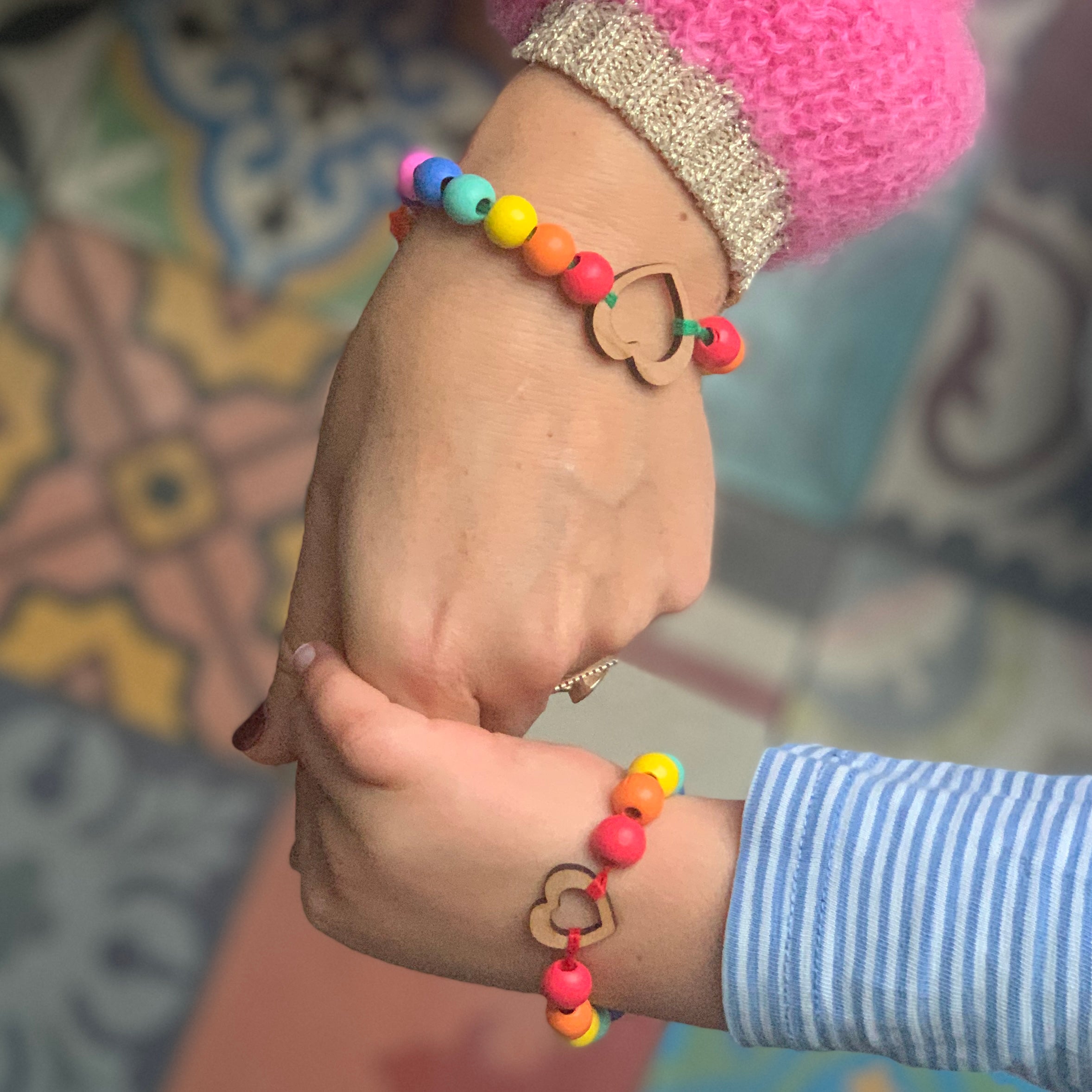 adult and child holding hands wearing bracelet