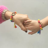 adult and child holding hands wearing bracelet