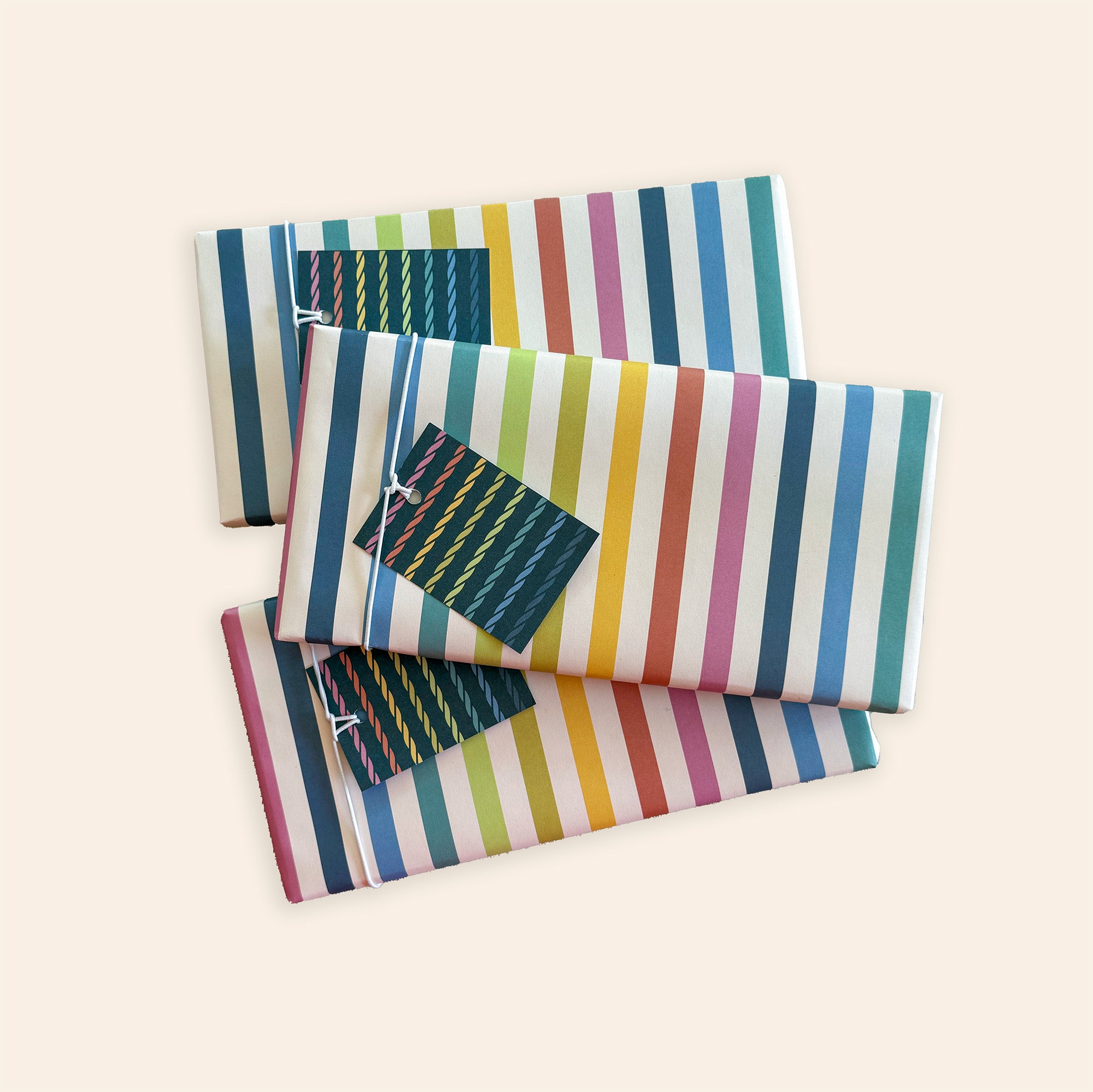 Three wrapped kits in dark blue gift wrap with playful illustrations and name tags