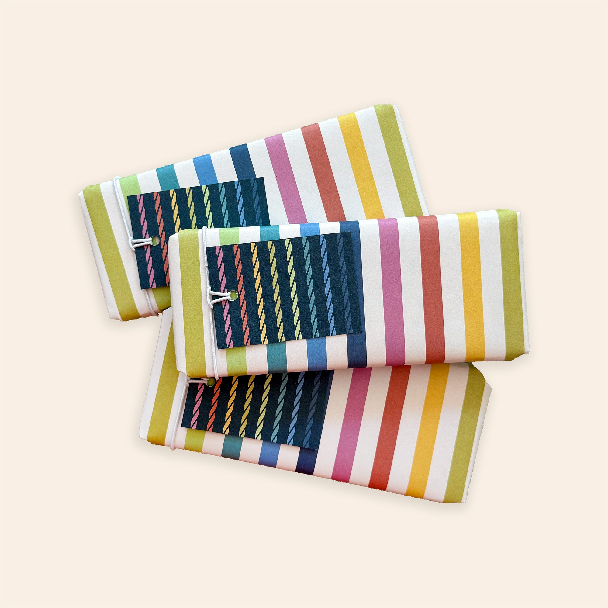 Three gift-wrapped tins in colourful paper and name tags