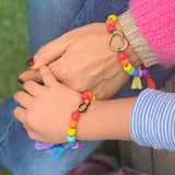 adult and child holding hands wearing bracelet